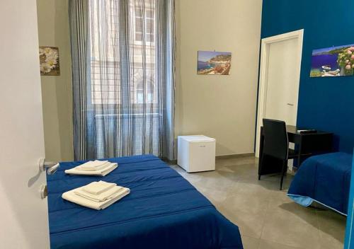 a room with a blue bed with towels on it at Oasi del Turista in Palermo