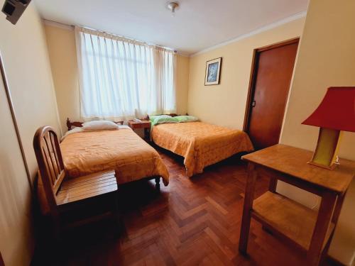 een hotelkamer met 2 bedden en een tafel bij huascaran guest house 2 estrellas in Huaraz