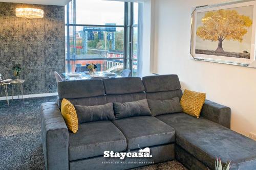 a living room with a brown couch in front of a window at Luxury 2bdr Flat With Canal View & Free Parking in Manchester