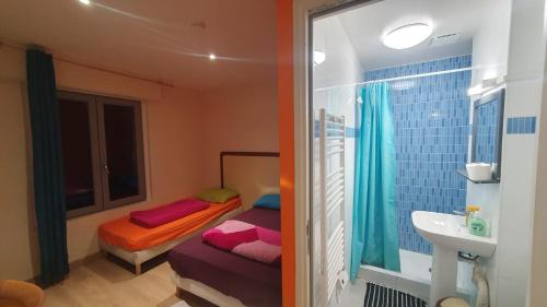 mała łazienka z łóżkiem i umywalką w obiekcie Hotel le Privilege w mieście La Courneuve