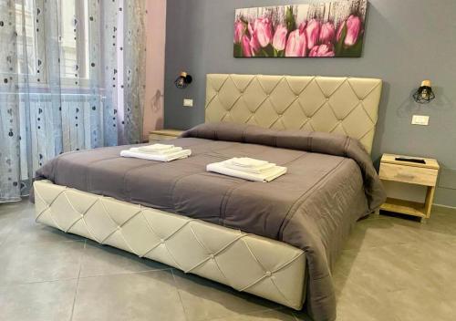 uma cama grande num quarto com tulipas cor-de-rosa em Oasi del Turista em Palermo