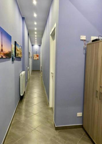 a hallway with blue walls and a tile floor at Oasi del Turista in Palermo