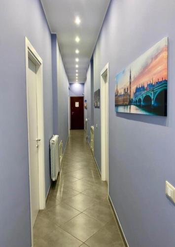 a hallway with blue walls and a painting on the wall at Oasi del Turista in Palermo