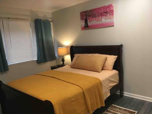 a bedroom with a bed with a yellow blanket at Townhouse, 2 bdrm, 2.5 bthrm, 2 qn bds/2 levls in Greenbelt