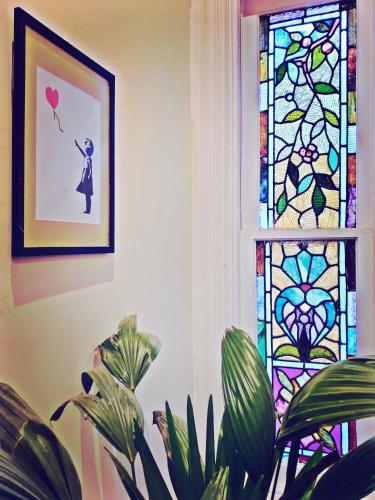 a stained glass window with a woman holding a balloon at Point Breeze Guest House in Pittsburgh