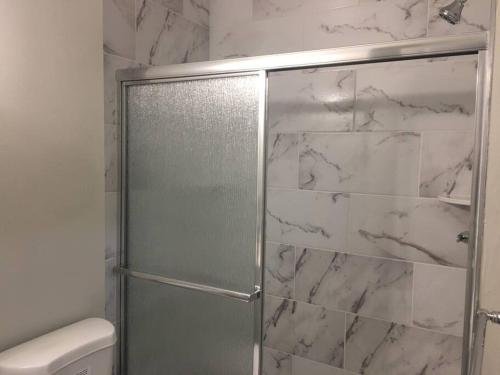 a shower with a glass door in a bathroom at Townhouse, 2 bdrm, 2.5 bthrm, 2 qn bds/2 levls in Greenbelt