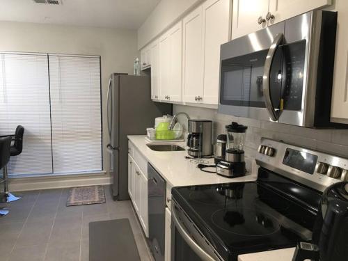 a kitchen with white cabinets and a black stove top oven at Entire Twnhouse 2bdrms 3Bthrm 2Qbeds 2Levls Fncd Bkyard in Greenbelt