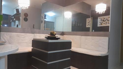 a bathroom with a bench and a mirror at Apartamento confortável e sofisticado em Aracaju in Aracaju