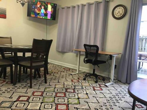 a dining room with a table and chairs and a clock at Entire Twnhouse 2bdrms 3Bthrm 2Qbeds 2Levls Fncd Bkyard in Greenbelt