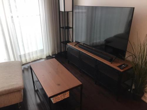 uma sala de estar com uma televisão de ecrã plano e uma mesa de centro em Home Away From Home em Toronto