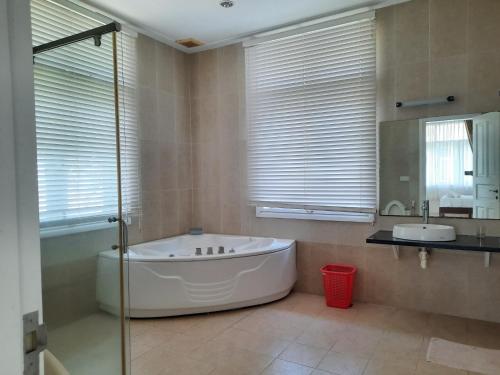 a bathroom with a large tub and a sink at Bougainviella - Sealinks Mũi Né - chuỗi biệt thự liền kề in Phan Thiet