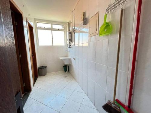 ein Badezimmer mit weißem Fliesenboden und einem Waschbecken in der Unterkunft Apto 50m da areia com wifi in Cabo Frio
