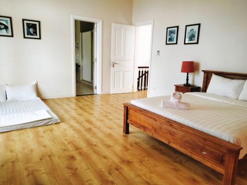 a bedroom with two beds and a wooden floor at Bougainviella - Sealinks Mũi Né - chuỗi biệt thự liền kề in Phan Thiet