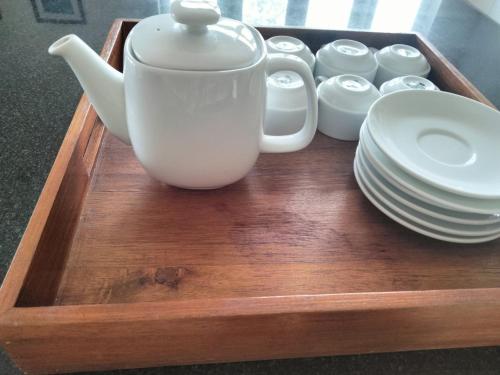 a tray with a tea pot and plates on it at Bougainviella - Sealinks Mũi Né - chuỗi biệt thự liền kề in Phan Thiet