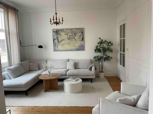 uma sala de estar com um sofá e uma mesa em Grand appartement charmant à 10 min de Lille em Tourcoing