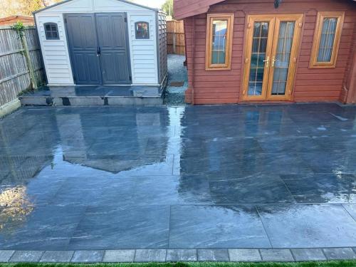 a patio with water in front of a house at Comfortable Annex in Orsett