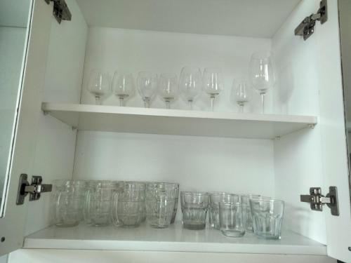 a bunch of glasses sitting on shelves in a room at Bougainviella - Sealinks Mũi Né - chuỗi biệt thự liền kề in Phan Thiet