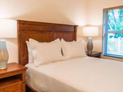 ein Schlafzimmer mit einem Bett mit weißen Kissen und zwei Lampen in der Unterkunft Seaside Villas in Fort Lauderdale