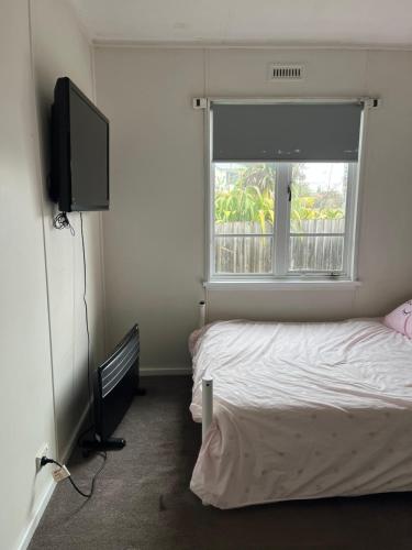 1 dormitorio con 1 cama, TV y ventana en Jennifer, en Warrane
