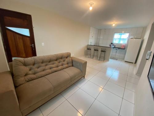 ein Wohnzimmer mit einem Sofa und einer Küche in der Unterkunft Temporada CG - Campina Apart-Hotel in Campina Grande