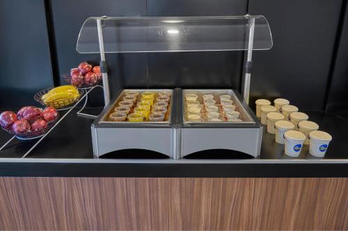 a display of donuts and cups of coffee on a counter at City Express by Marriott Tijuana Rio in Tijuana