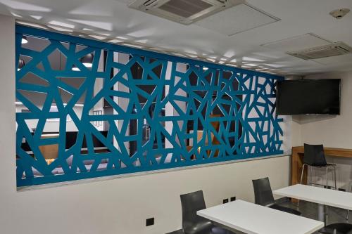 a wall mural in a meeting room with tables at City Express by Marriott Tijuana Rio in Tijuana