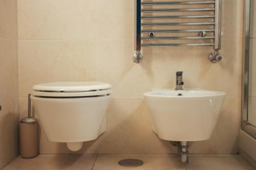 a bathroom with a toilet and a sink at Sotto Il Cielo Hotel in Pignola