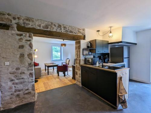 une cuisine avec un comptoir et un salon dans l'établissement Gîte Vosgien Rénové avec Jardin, Proche Gérardmer et Activités de Plein Air - FR-1-589-600, à Jussarupt