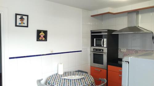 a kitchen with a table and a black refrigerator at Unos días en Hendaye, la desconexión que necesita in Hendaye
