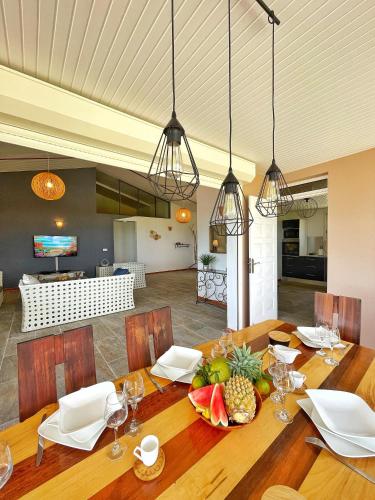 a dining room with a table with fruit on it at Villa Sweet Caraïbes, vue mer, jacuzzi in Les Trois-Îlets