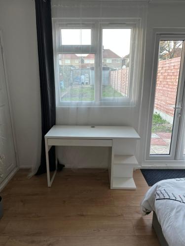 a white bench sitting in front of a window at Self-contained en-suite room in Wembley in London