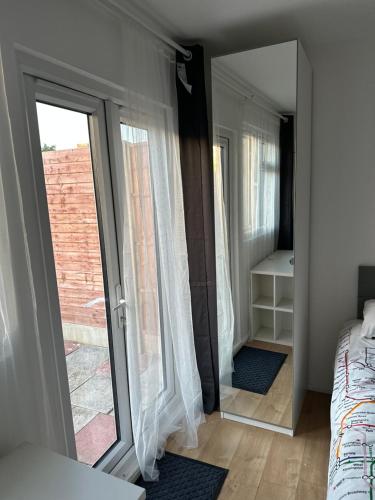 a bedroom with a mirror and a bed and a window at Self-contained en-suite room very close to Wembley stadium in London