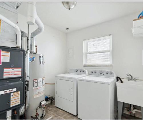 a kitchen with a washing machine and a sink at Modern River Retreat near airport, hospitals, businesses 