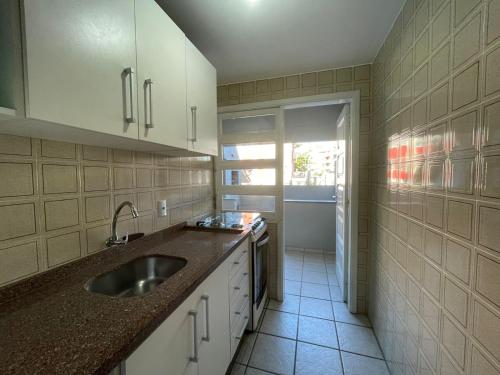 eine Küche mit einer Spüle und einer Arbeitsplatte in der Unterkunft Edificio Daniela Ap 102 in Bombinhas