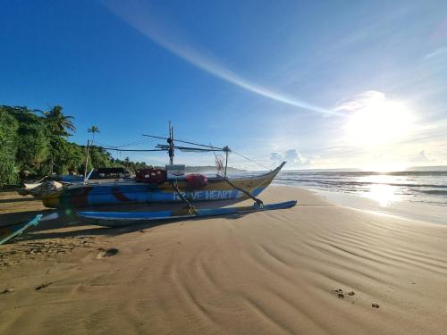 a boat sitting on the sand on a beach at Relax Beach House in Tangalle