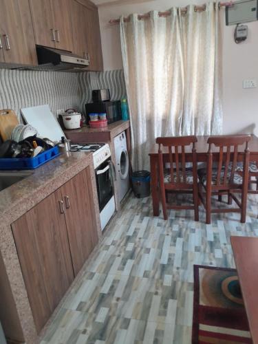 a kitchen with a stove and a table and chairs at Apartment Rupas in Kathmandu