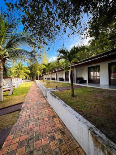 a brick path in front of a building with palm trees at Verde Mar Pipa Beach in Pipa