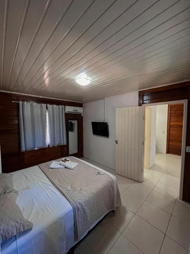 a bedroom with a bed and a flat screen tv at Verde Mar Pipa Beach in Pipa