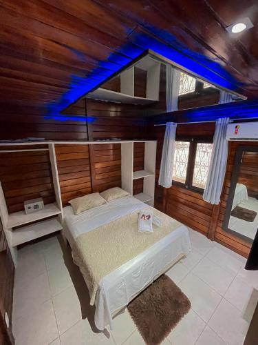 a bedroom with a bed in a room with wooden walls at Verde Mar Pipa Beach in Pipa