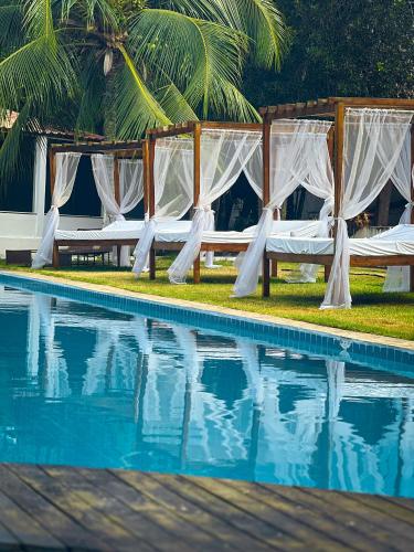 a pool with a canopy and chairs next to a poolspective at Verde Mar Pipa Beach in Pipa