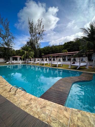 a large swimming pool with a wooden deck at Verde Mar Pipa Beach in Pipa