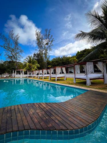 a pool at a resort with a wooden boardwalk at Verde Mar Pipa Beach in Pipa