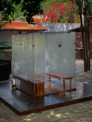a glass wall with a wooden table and a bench at Verde Mar Pipa Beach in Pipa