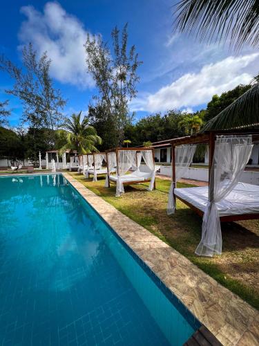 a pool at the resort with chairs and a canopy at Verde Mar Pipa Beach in Pipa