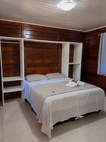 a bedroom with a large bed with wooden walls at Verde Mar Pipa Beach in Pipa