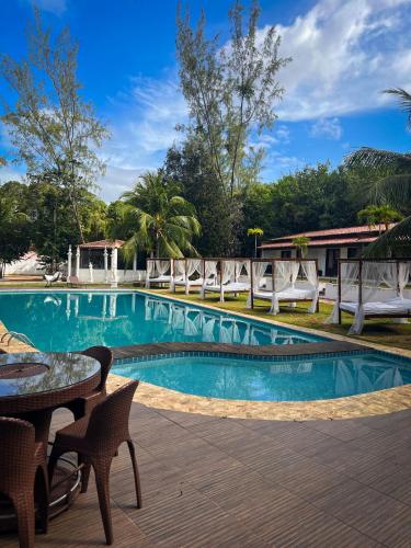 a swimming pool with a table and chairs next to it at Verde Mar Pipa Beach in Pipa