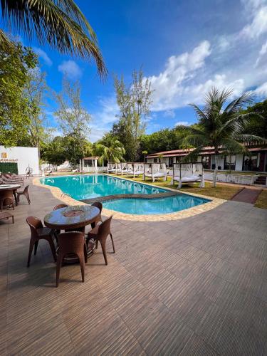a swimming pool with tables and chairs and a table at Verde Mar Pipa Beach in Pipa