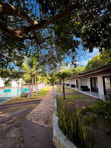 a brick path in front of a building with trees at Verde Mar Pipa Beach in Pipa