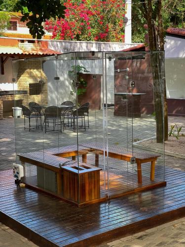 a glass house on a wooden deck with a table at Verde Mar Pipa Beach in Pipa