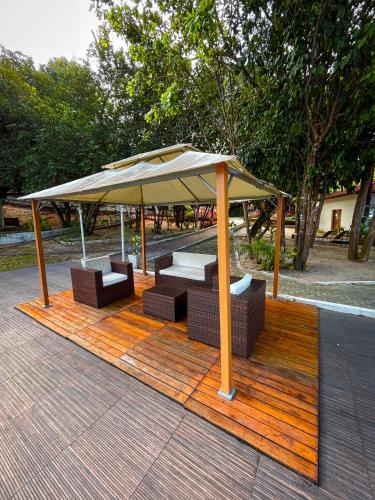 a pavilion with chairs and an umbrella on a deck at Verde Mar Pipa Beach in Pipa